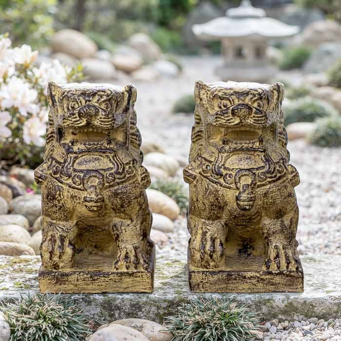 Par de esculturas de leões Fu guardiões artesanais em fibrocimento envelhecido de Bali em jardim oriental.