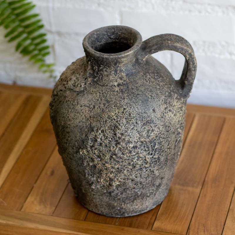 Vaso rústico Perunggu em terracota com acabamento texturizado bronze e alça lateral artesanal de Bali.
