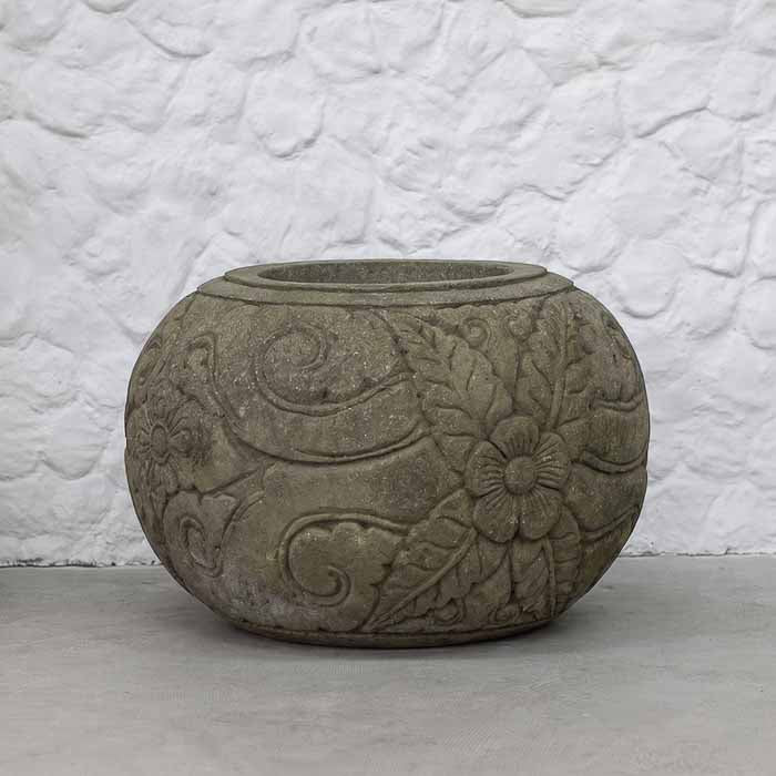 Vaso esférico em pedra vulcânica cinza com entalhes florais em alto-relevo esculpidos à mão.