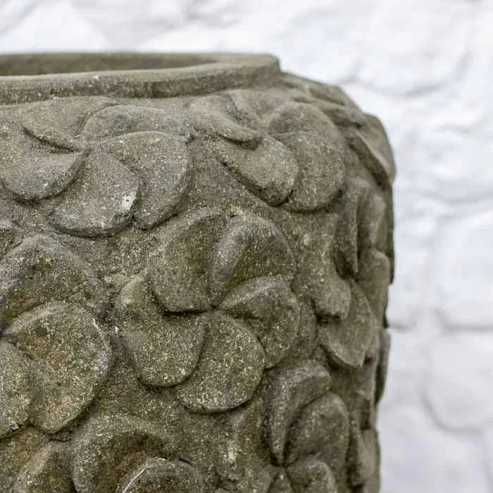 Detalhe do trabalho manual indonésio em vaso de pedra com padrão floral repetitivo.