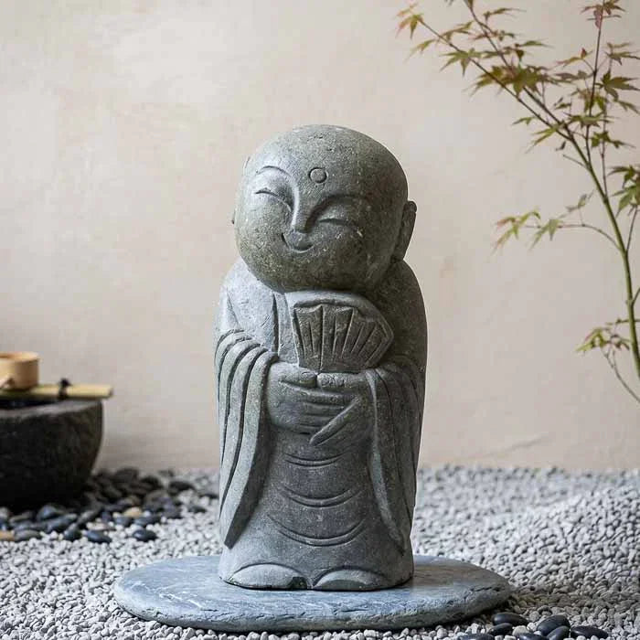Estátua de monge sorridente artesanal esculpida em pedra vulcânica natural de Bali para jardim. 