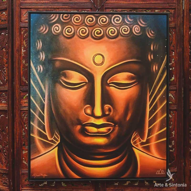 Quadro emoldurado com pintura da face de Buda em tons de dourado e marrom com olhos fechados. 