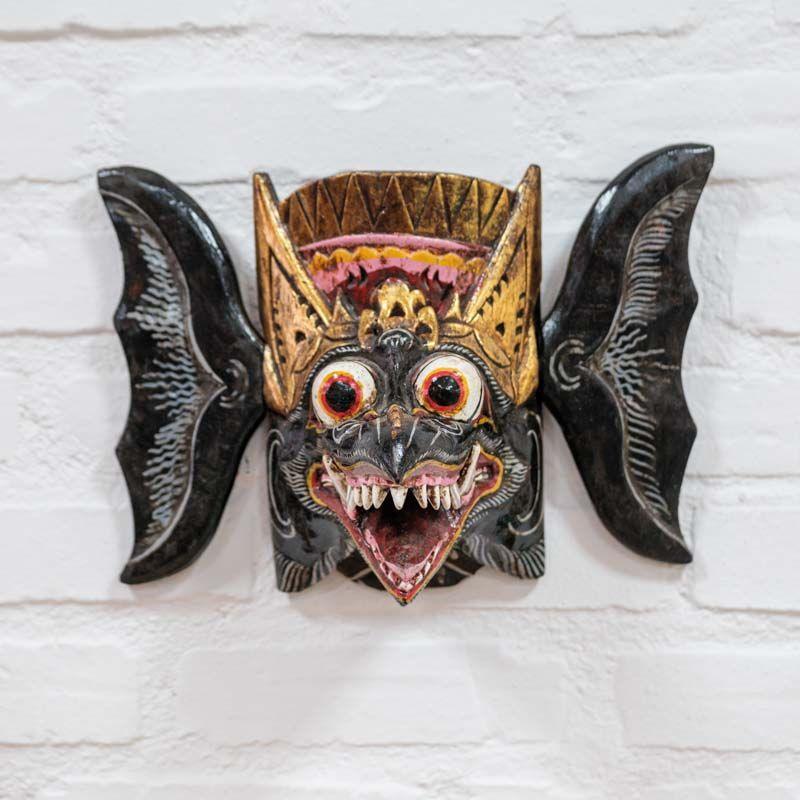 Máscara decorativa de parede artesanal Rangda entalhada em madeira com detalhes dourados e expressão mística de Bali. 