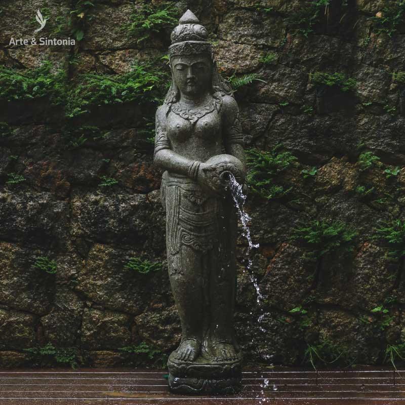 Detalhe da deusa Dewi Sri segurando um jarro por onde verte a água em fonte artesanal.